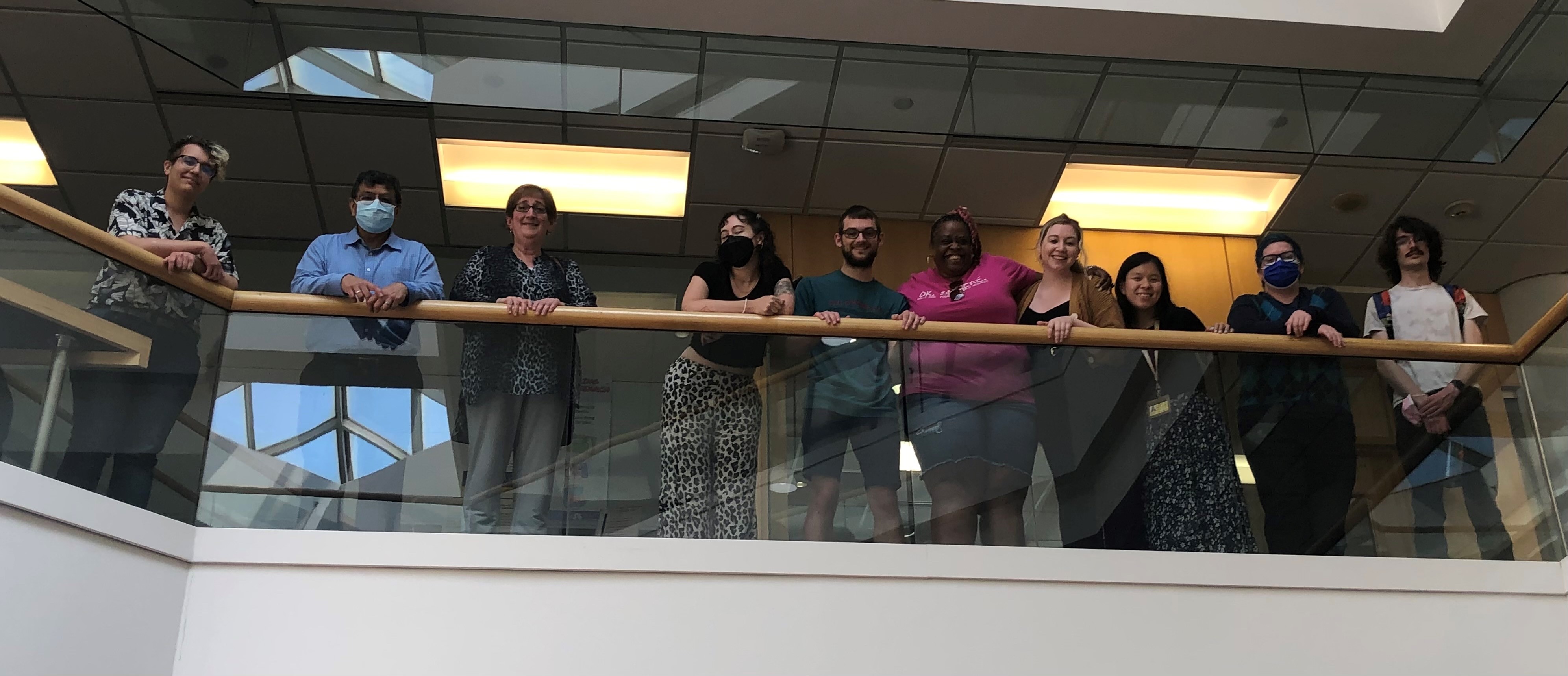 Libraries staff stand around the railing on the 2nd floor of the library